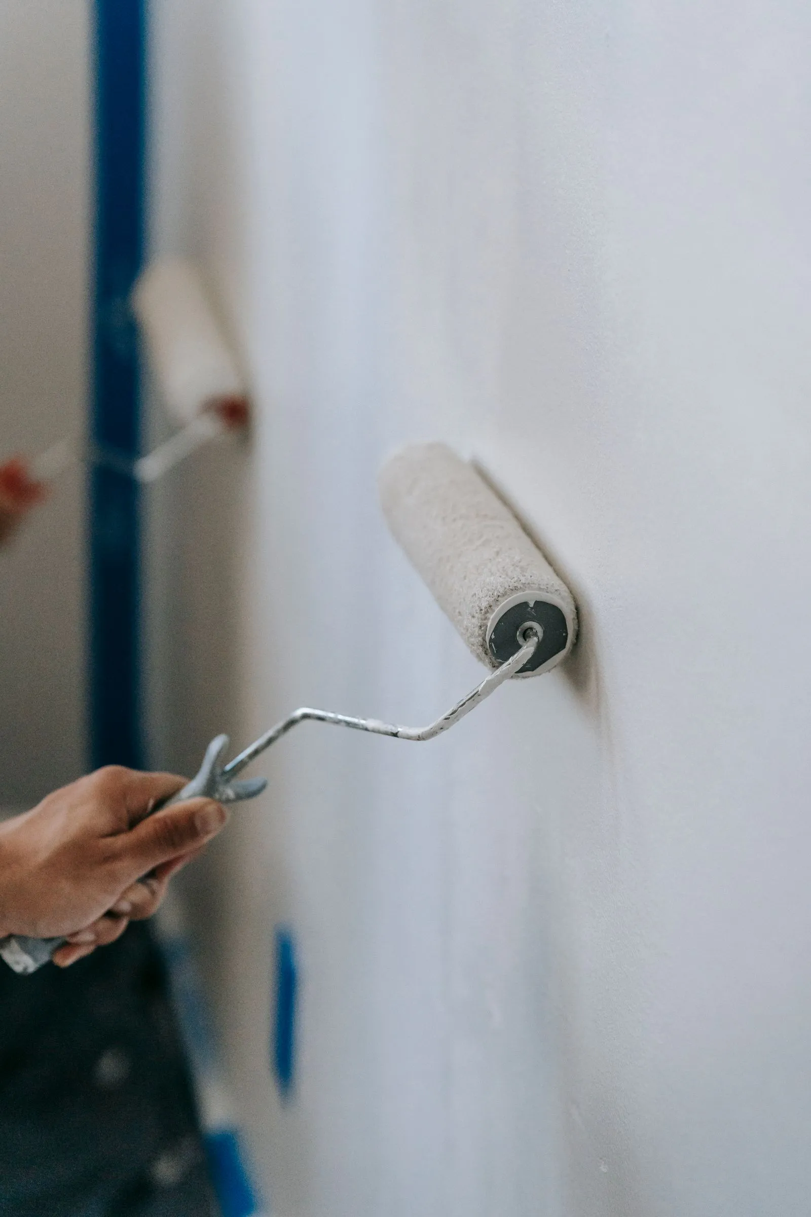 Anstrich einer Wand mit der Farbrolle nach sauberem Abkleben